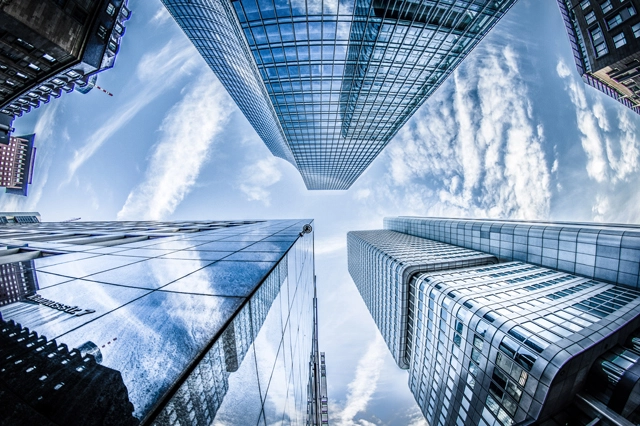 low angle photo of four high rise curtain wall buildings